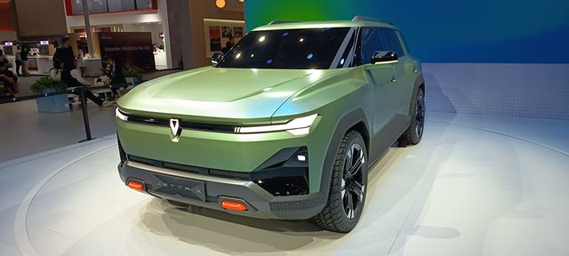 Veículo SUV concept em tom verde, exibindo design moderno e arrojado, com rodas pretas e detalhes em laranja, em um estande de exposição.