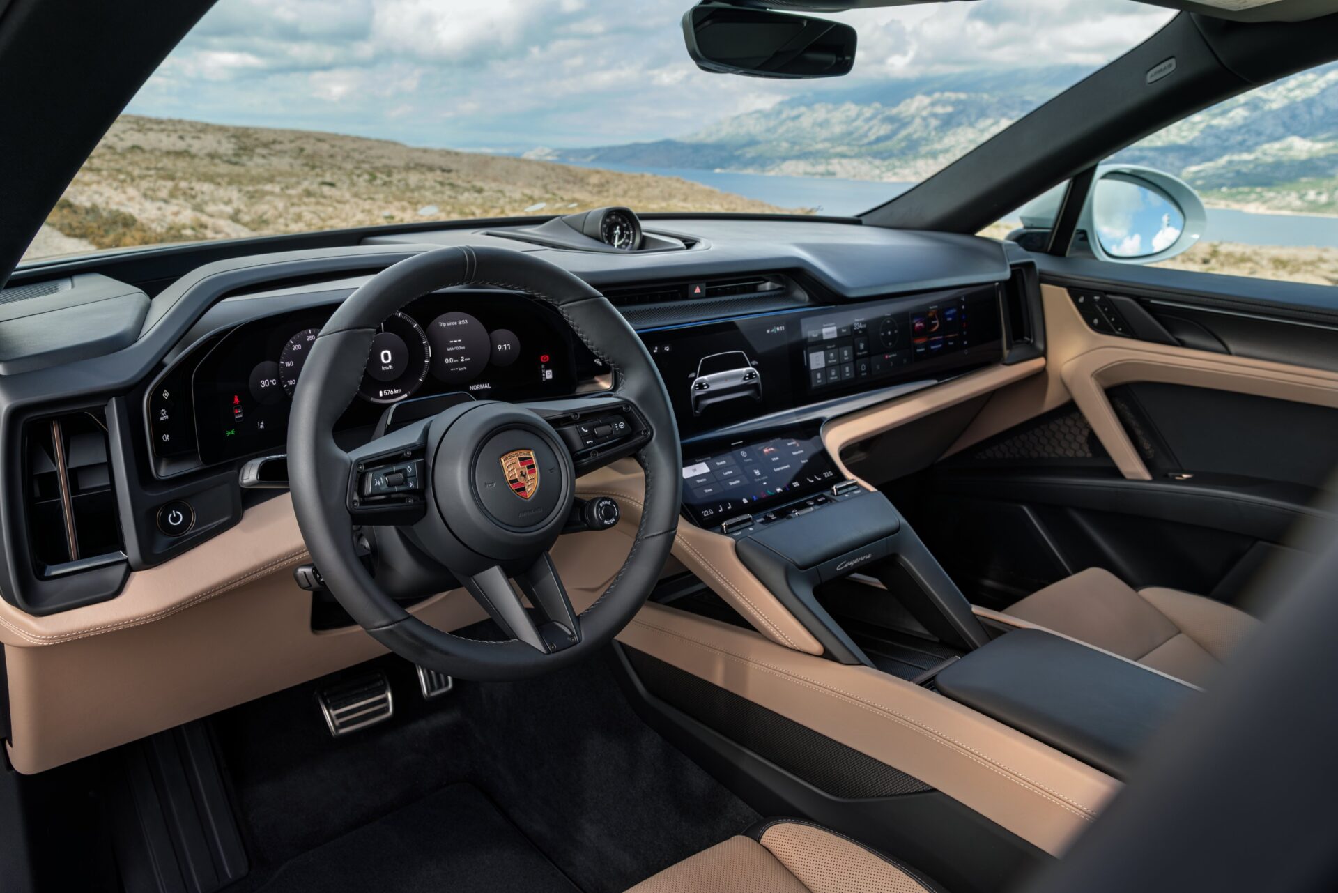 Interior view of a Porsche car showcasing a modern dashboard, steering wheel, and high-tech screens with a scenic landscape in the background.