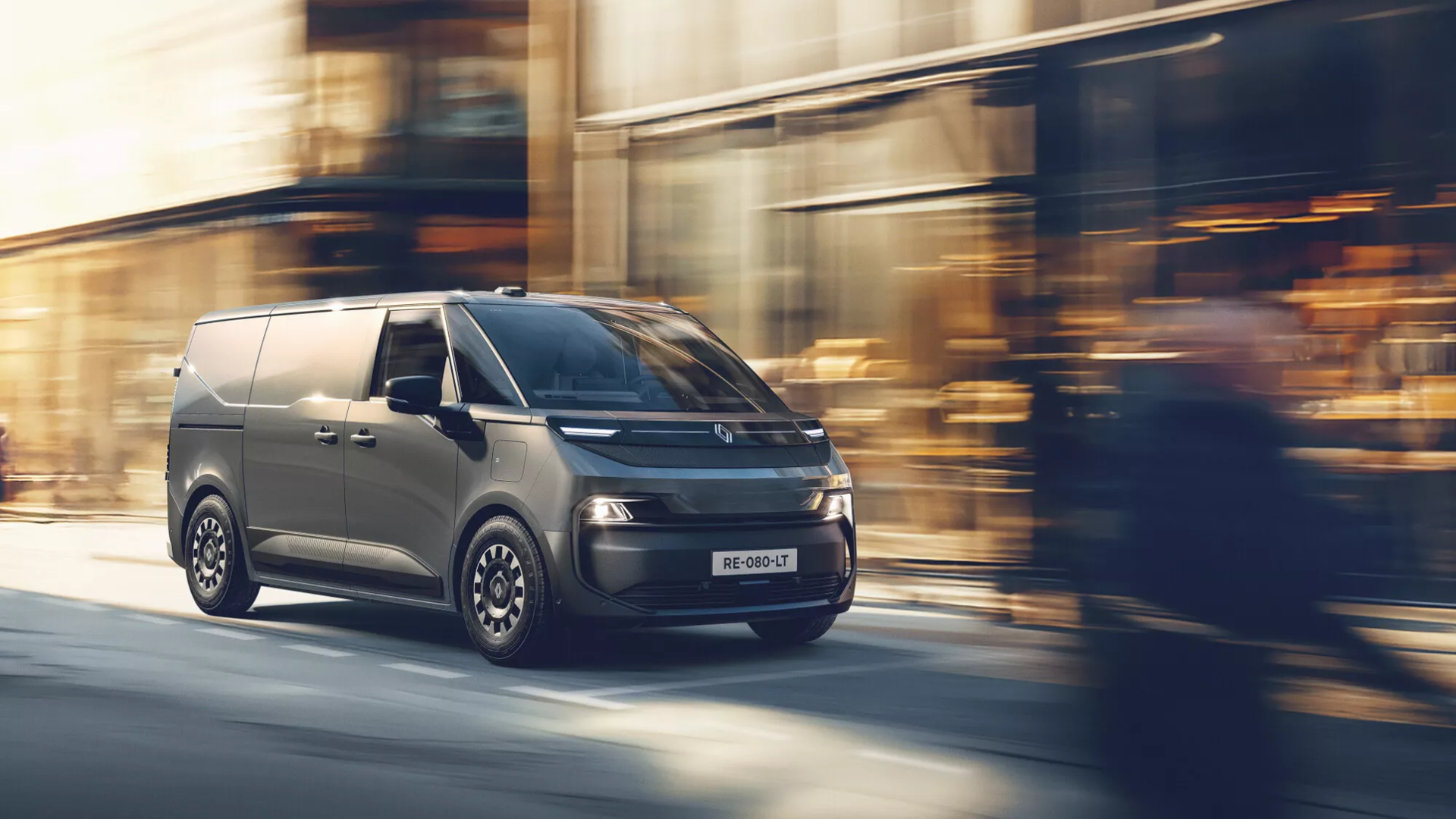 A sleek, modern van in motion on a city street, showcasing a contemporary design with a gray exterior and stylish wheels.