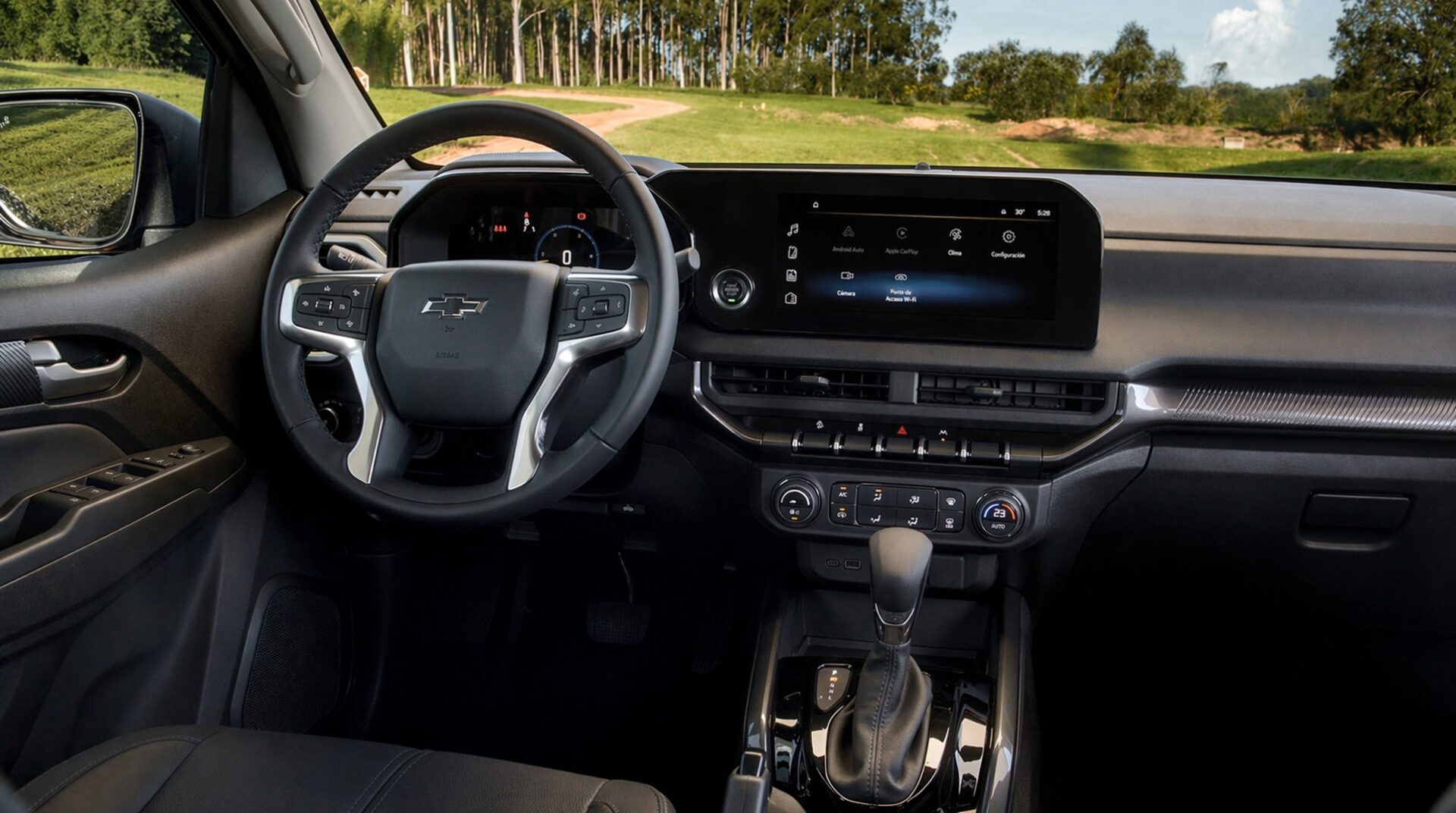 Interior view of a modern car dashboard featuring a steering wheel, digital display, and gear shift, set against a backdrop of trees and a dirt road.