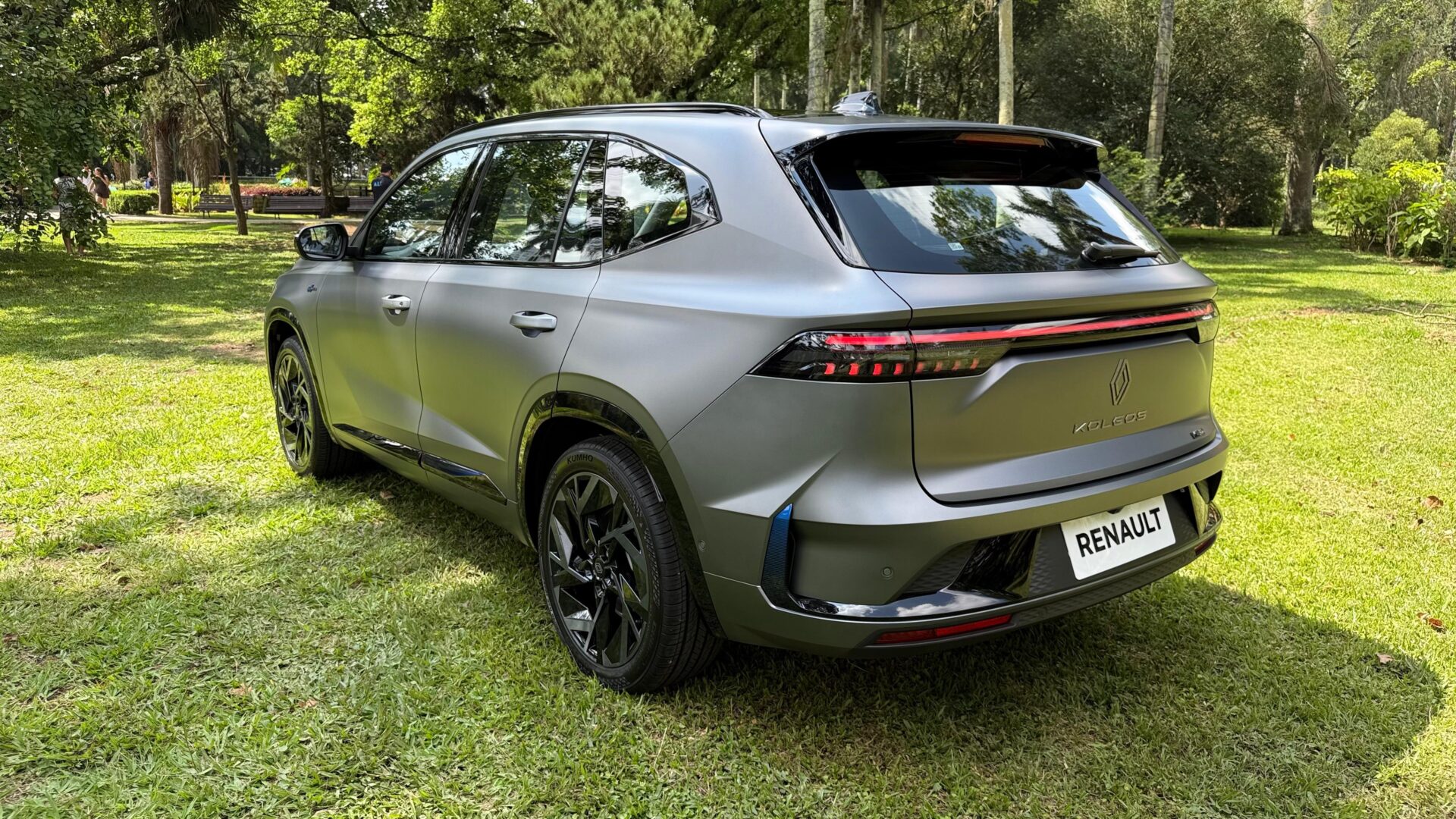 SUV Renault Koleos em um ambiente ao ar livre, visto de perfil, com destaque para a traseira e rodas pretas.