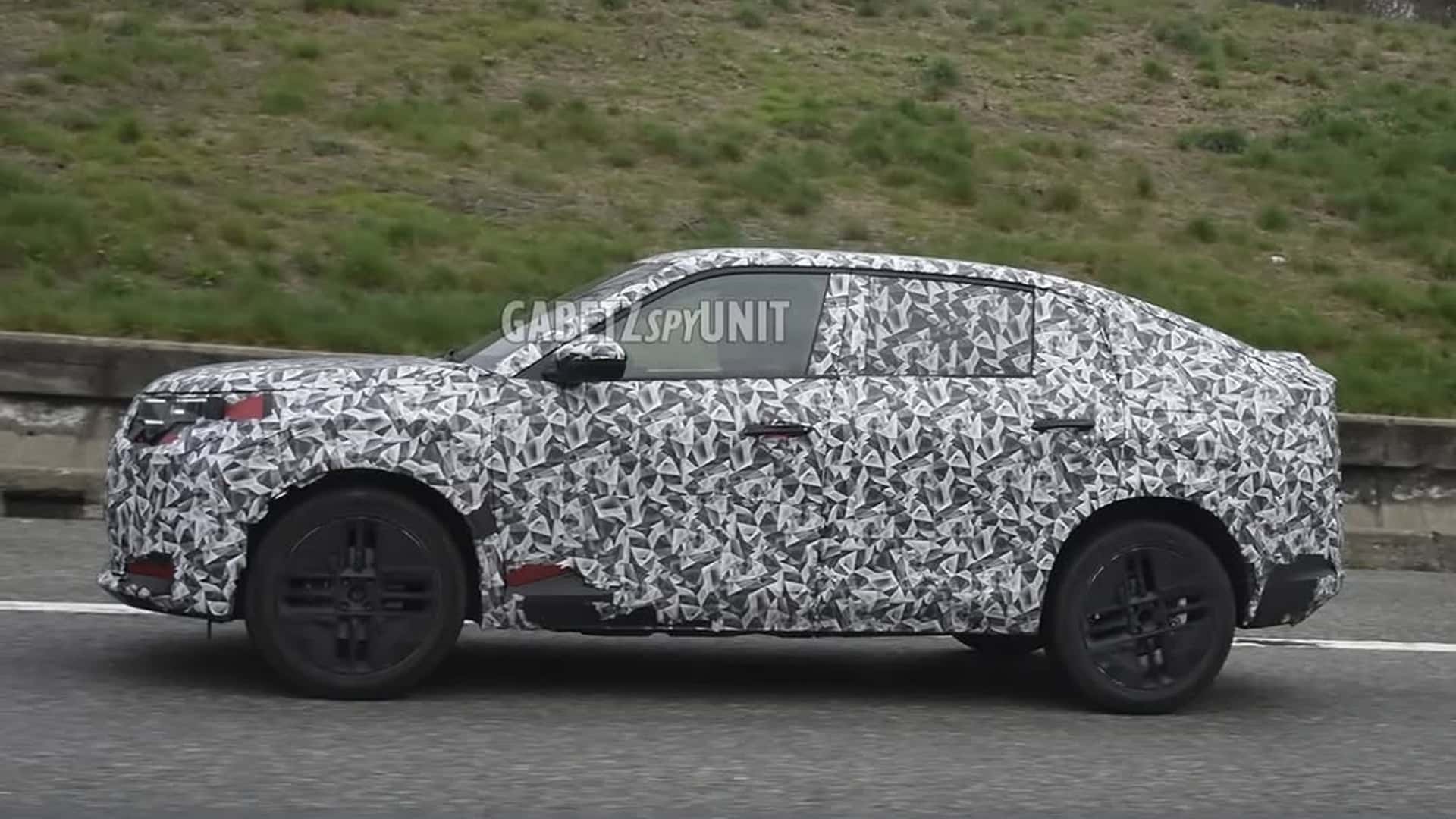 Um carro camuflado em um estrada, mostrando a lateral com um padrão de disfarce em preto e branco.