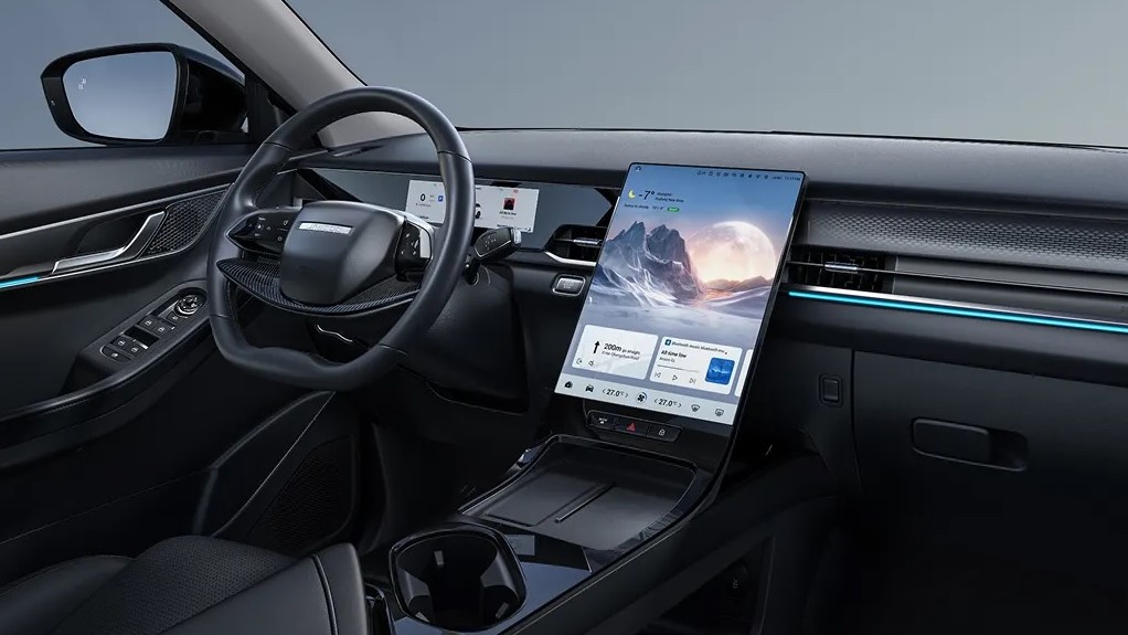 Interior de um carro moderno com volante e tela digital grande no painel.