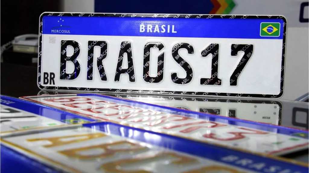 Placa de veículo do Brasil com os caracteres 'BRAGS17', em um fundo com a bandeira do Brasil e elementos do Mercosul.