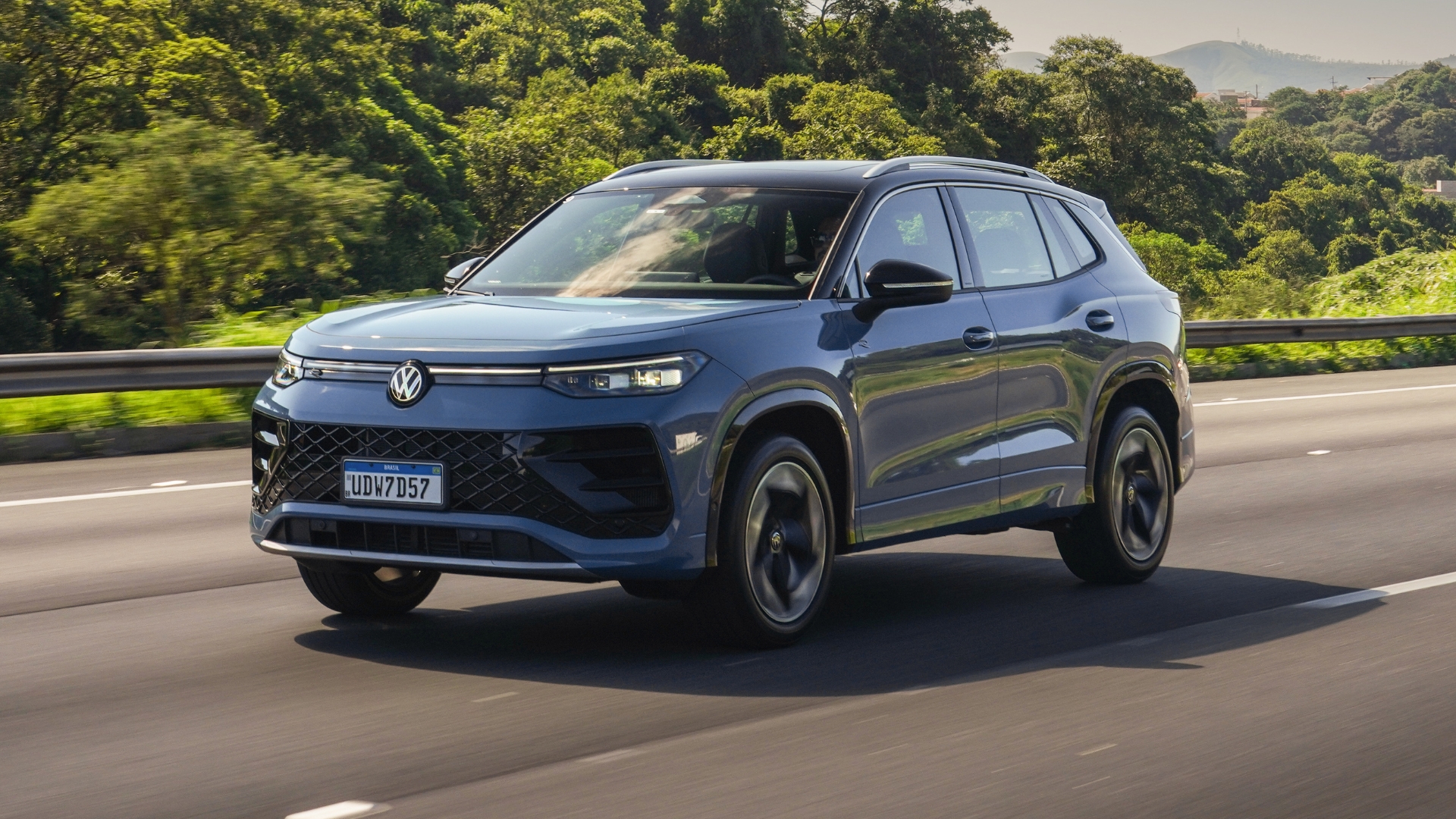 Um veículo SUV Volkswagen em movimento em uma estrada, com vegetação ao fundo.