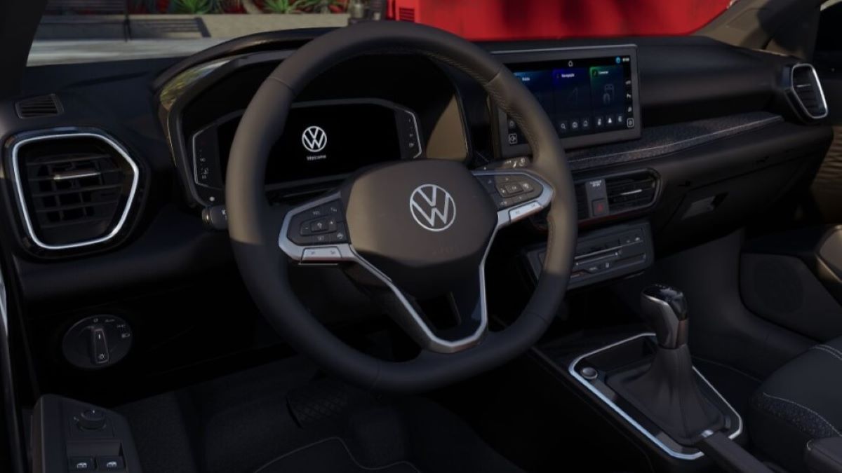 Interior de um carro Volkswagen, destacando o volante com o logotipo da marca, painel digital e console central com transmissor.