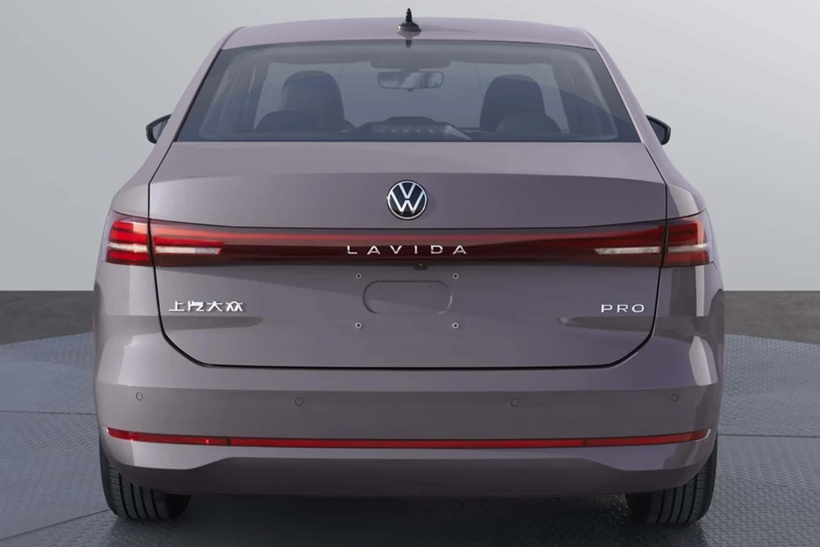 Vista traseira de um carro Volkswagen Lavida PRO, na cor cinza, com símbolo da marca e detalhes em vermelho nas lanternas.