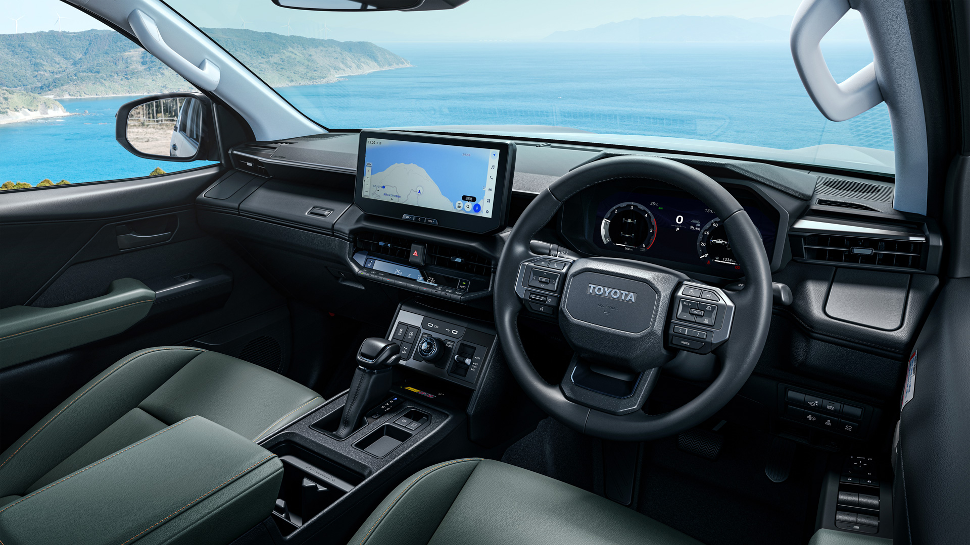 Interior de um carro Toyota, com painel moderno, volante, tela de navegação e vista para o mar ao fundo.