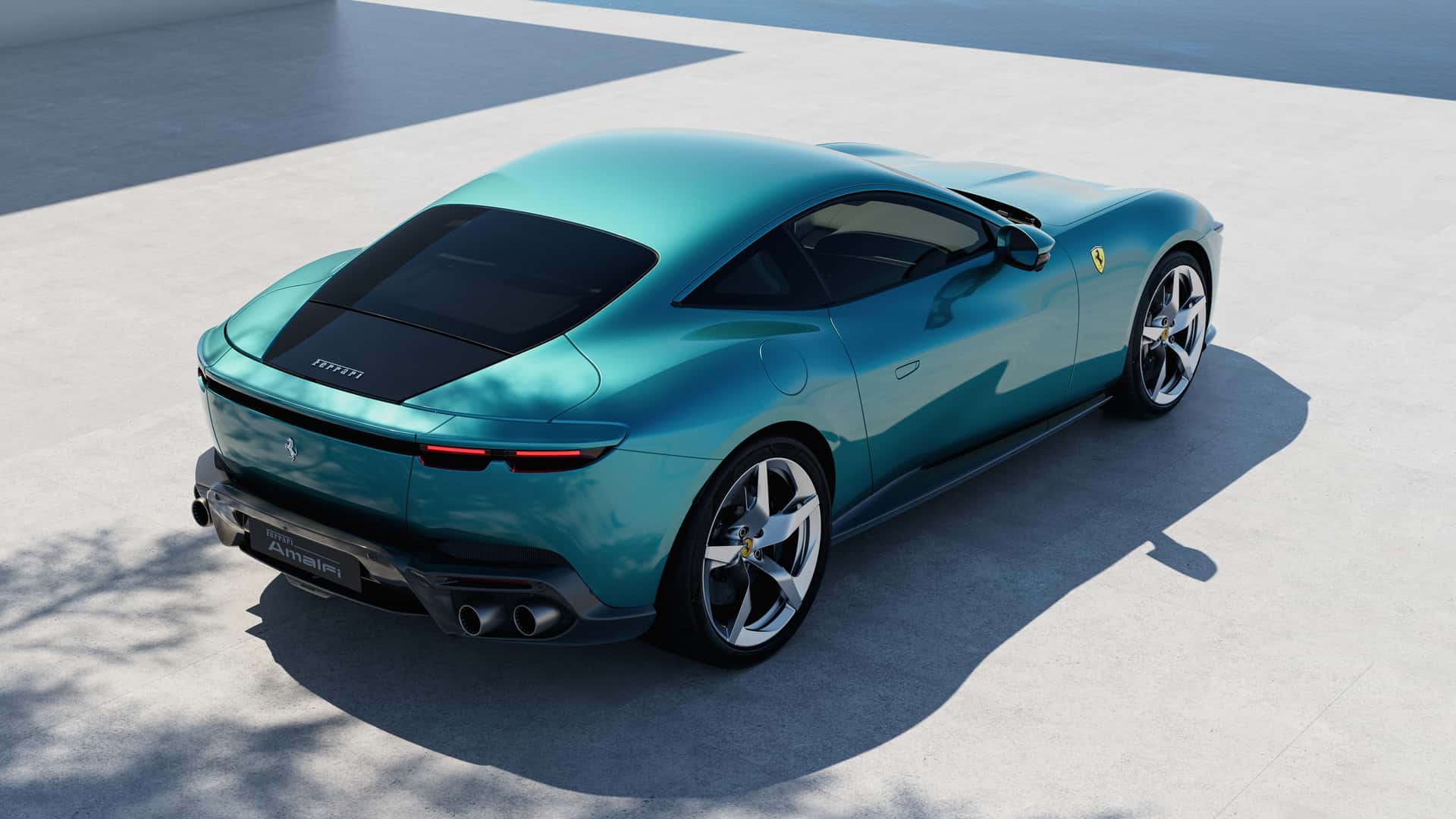 Vista traseira de um carro esportivo da Ferrari, com pintura em tom azul-esverdeado, estacionado em uma superfície clara, refletindo luz.