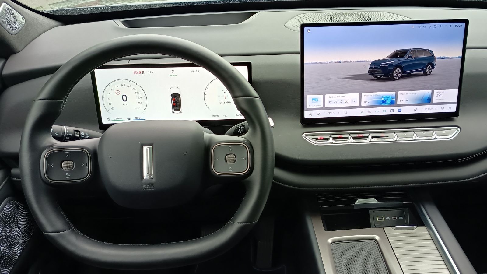 Interior de um carro com painel digital, volante e uma tela sensível ao toque exibindo informações do veículo.