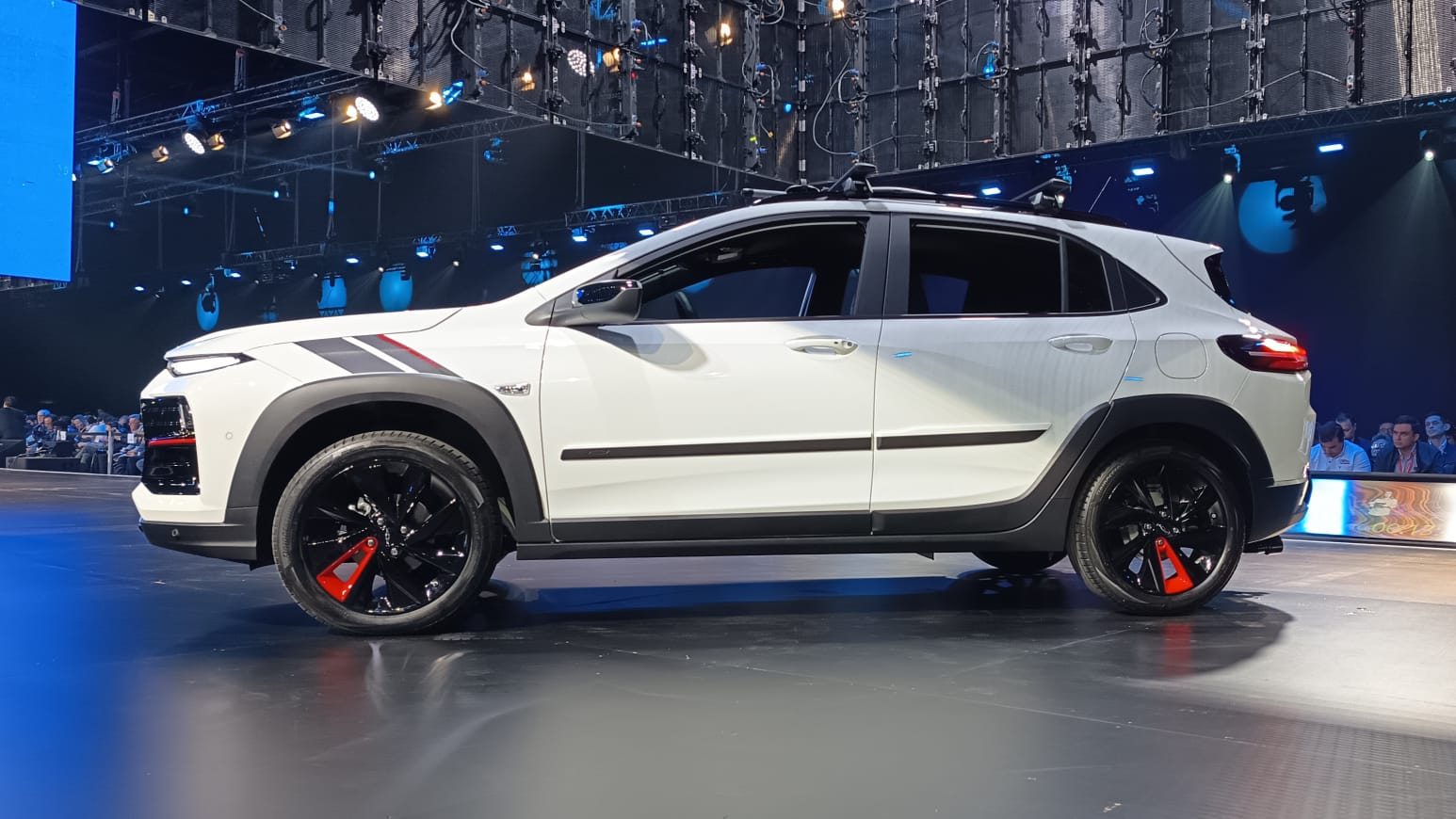 SUV moderno branco em um evento, com rodas pretas e detalhes coloridos