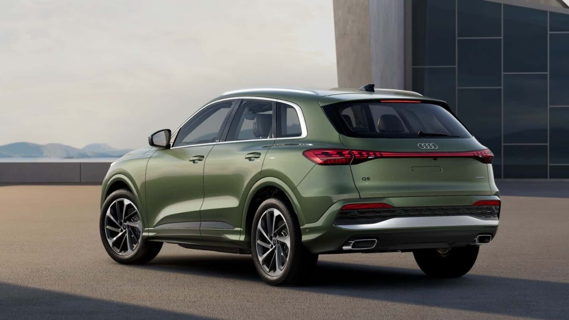 SUV Audi Q5 na cor verde, visto de trás e do lado esquerdo, em um ambiente urbano.