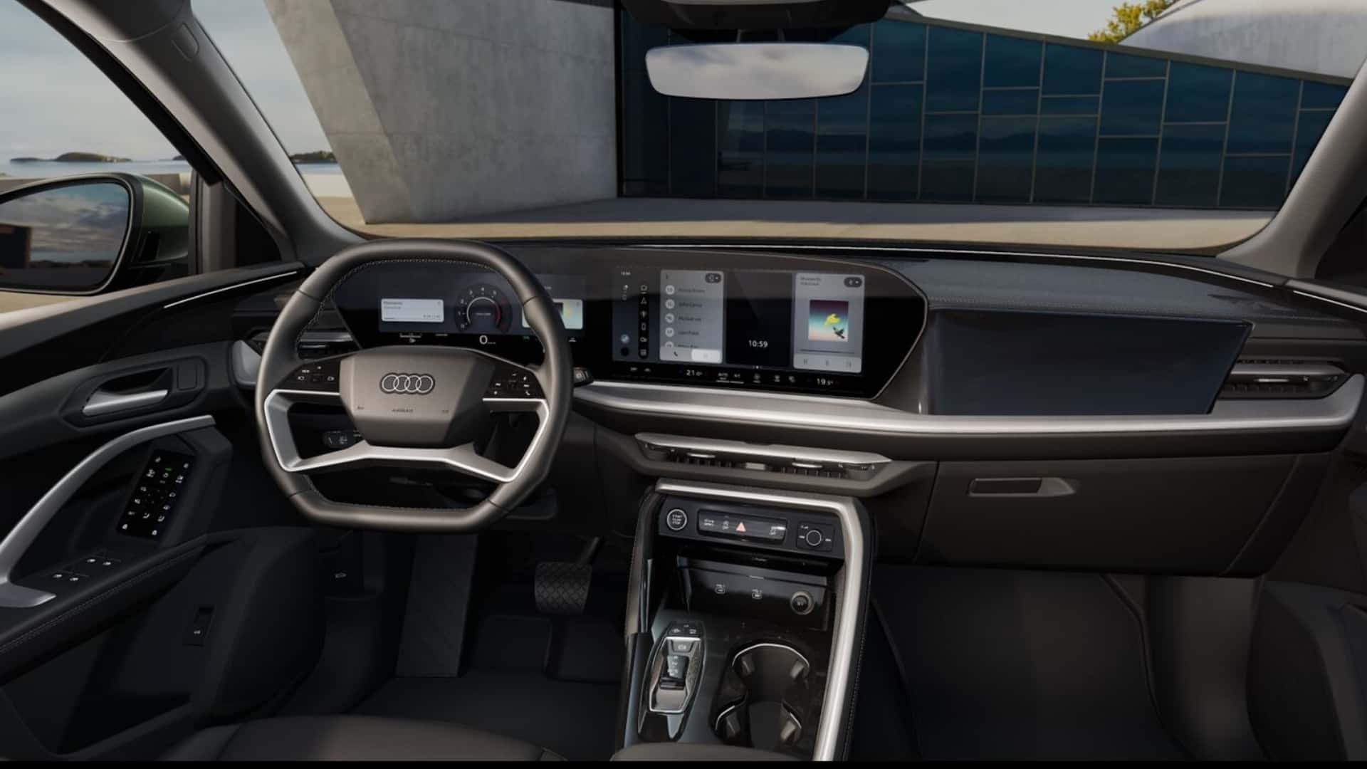 Interior de um carro Audi, destacando o volante moderno, o painel digital e as telas de controle no console.