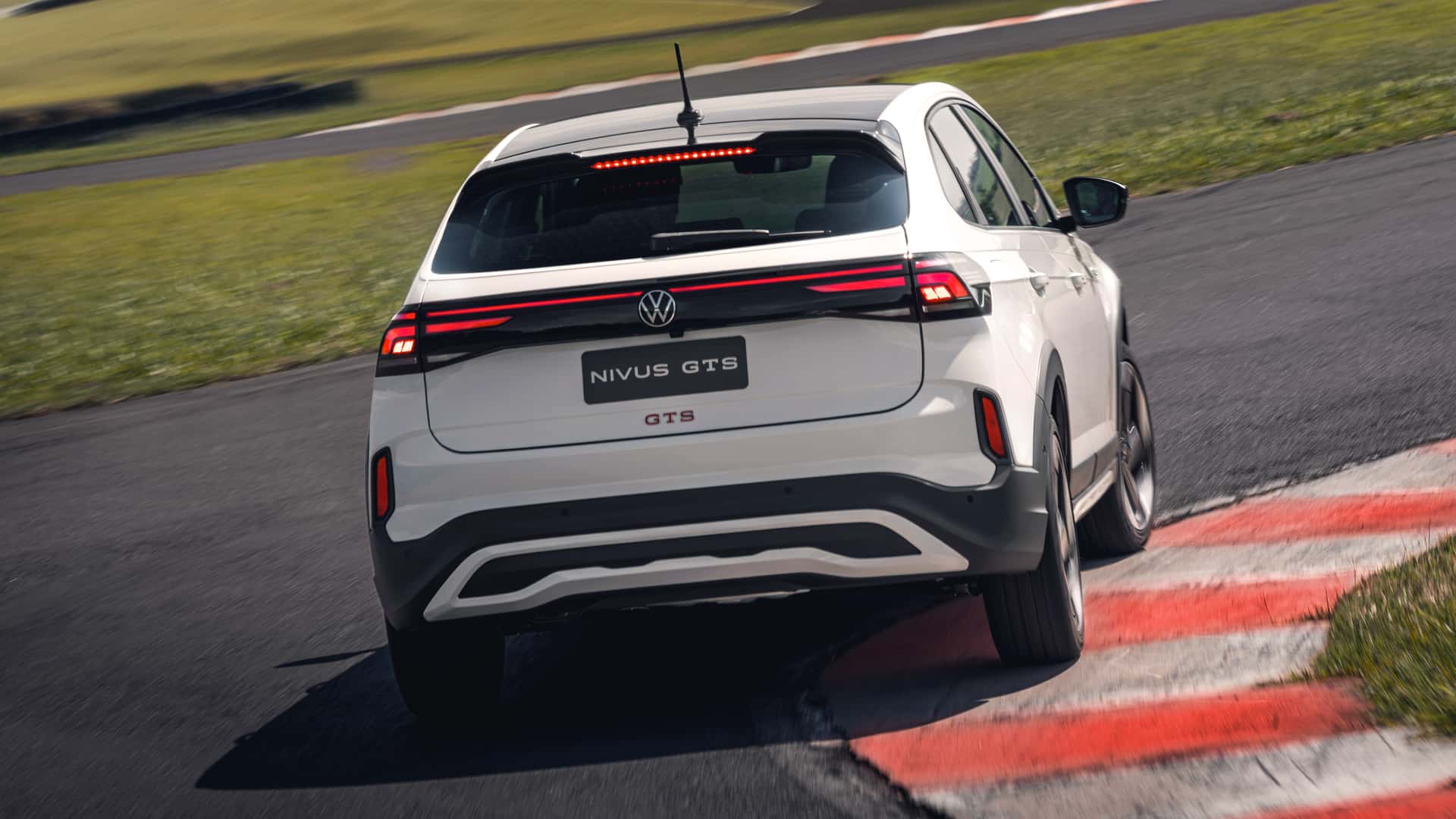 Um carro Volkswagen Nivus GTS em uma pista, visto de trás, fazendo uma curva.