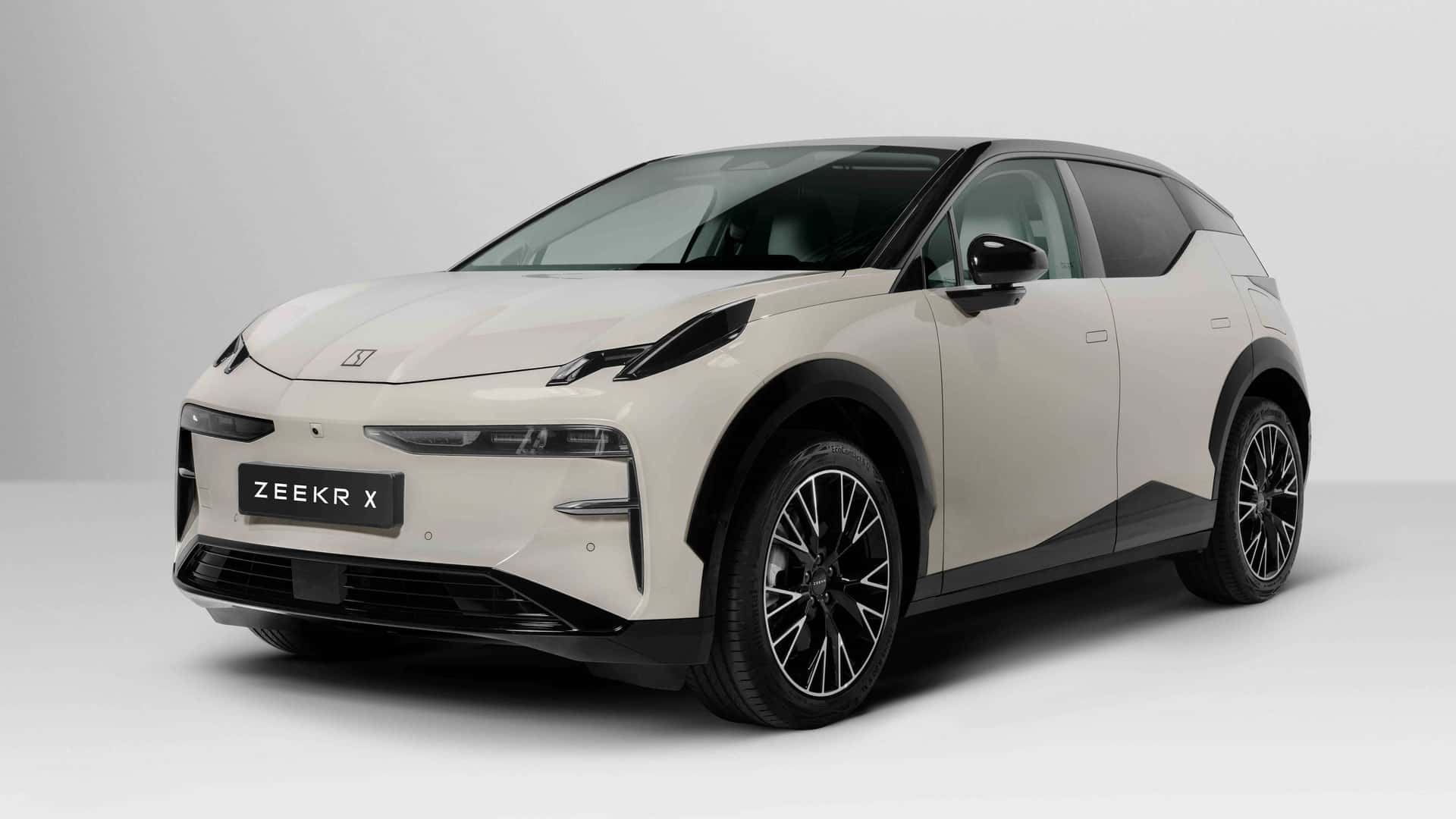 Carro elétrico Zeekr X em uma vista frontal, apresentando design moderno e elegante, com cores claras e rodas de liga leve.