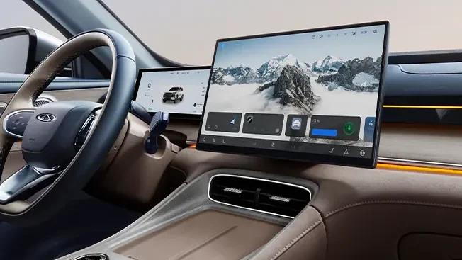 Interior de um carro moderno com um painel de controle digital e uma tela grande exibindo uma imagem de montanhas.