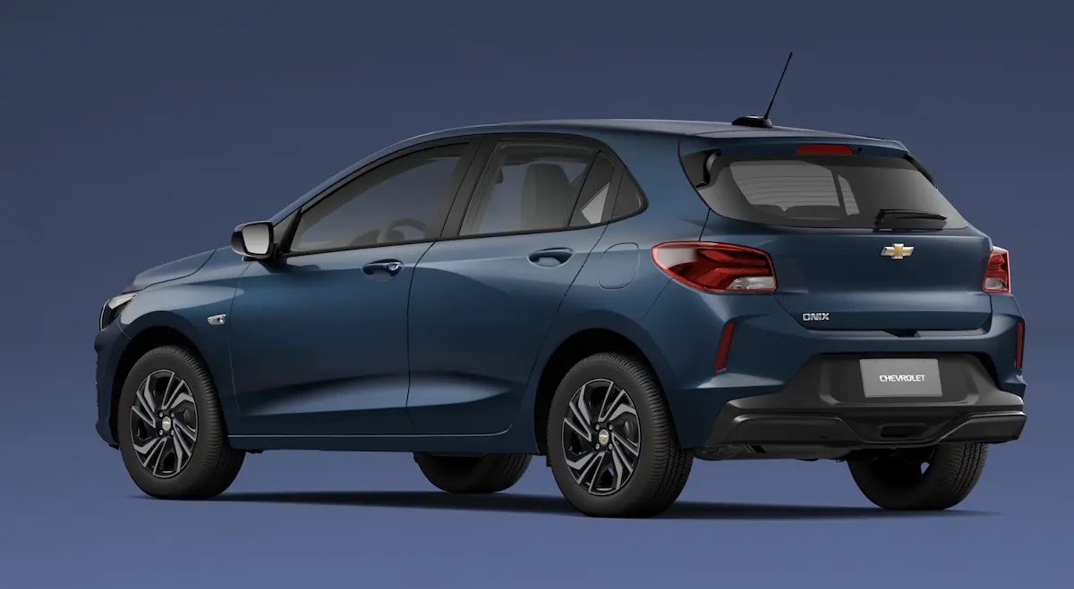 Rear view of a blue Chevrolet Onix hatchback against a dark background, showcasing its sleek design and modern features.