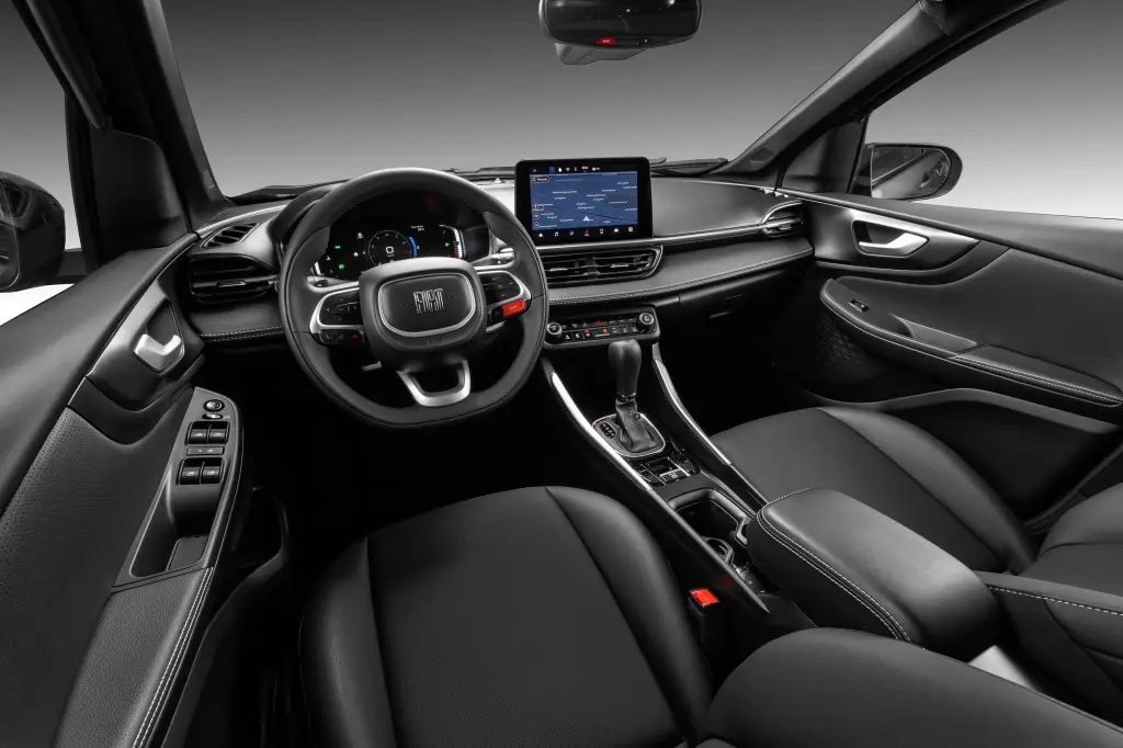 Interior view of a car showing a modern dashboard, steering wheel, and front seats, featuring a digital display and control knobs.