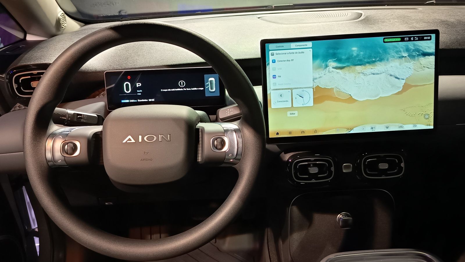 Painel do interior de um carro elétrico, mostrando o volante, display digital e tela touchscreen com interface de controle.