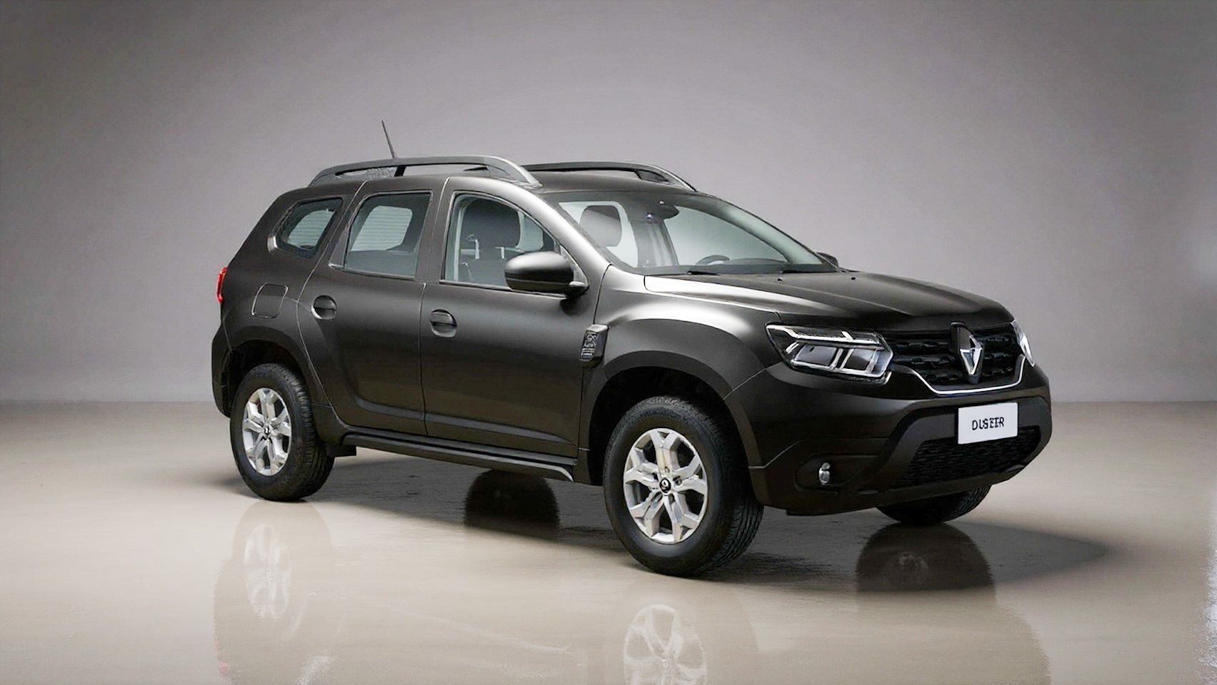 Imagem de um carro Renault Duster na cor preta, estacionado em um ambiente iluminado com fundo neutro.