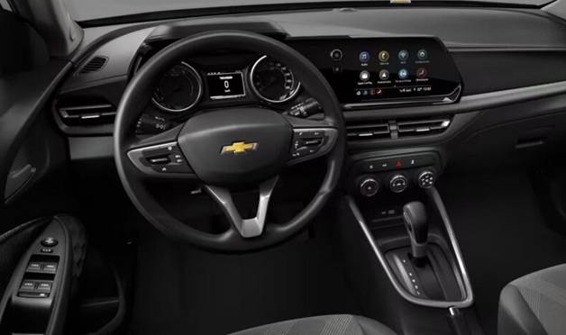 Interior view of a Chevrolet vehicle showcasing the steering wheel, dashboard with digital display, and center console with gear shifter and climate controls.