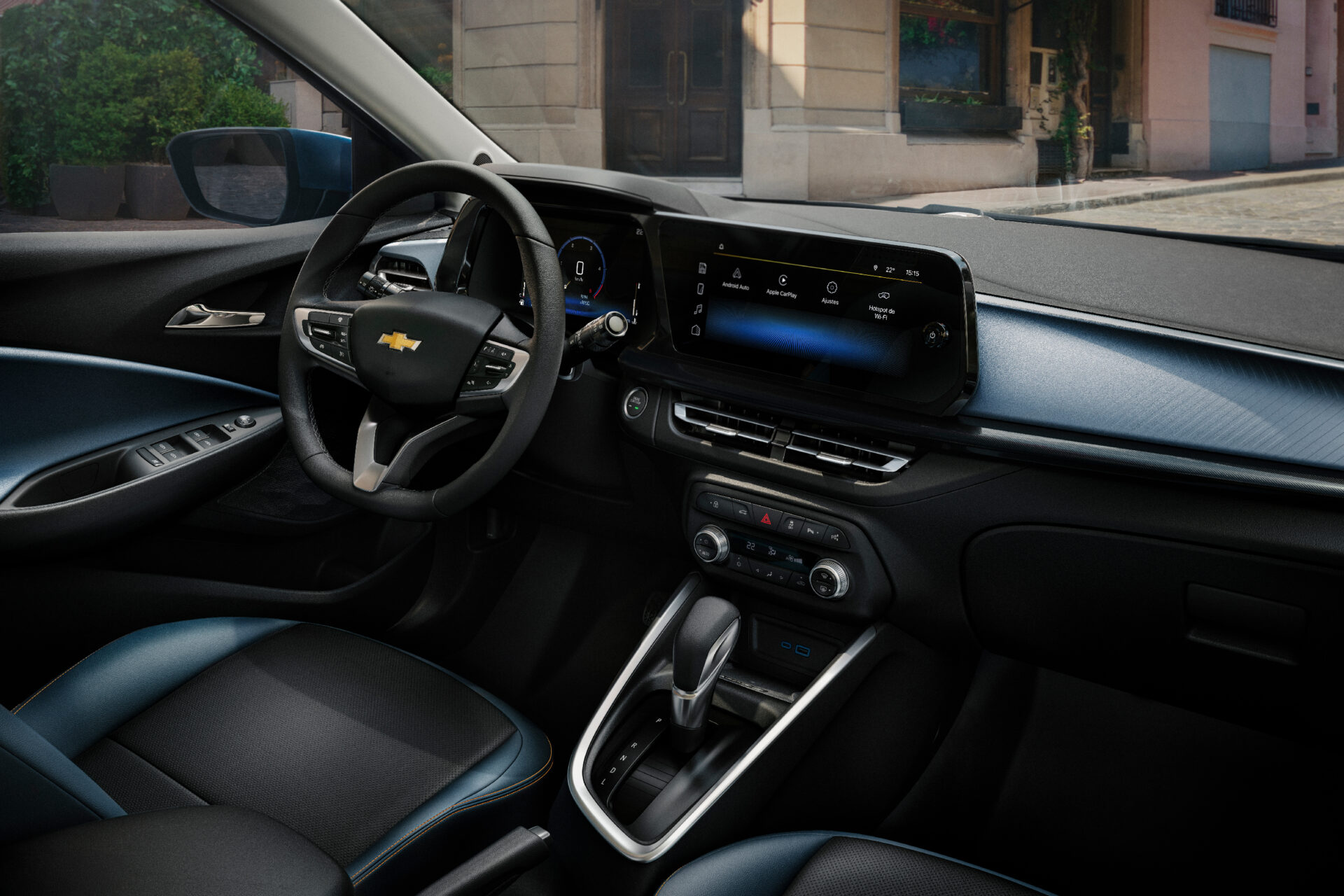 Interior view of a Chevrolet car, featuring a steering wheel, touchscreen display, and gear shift console.