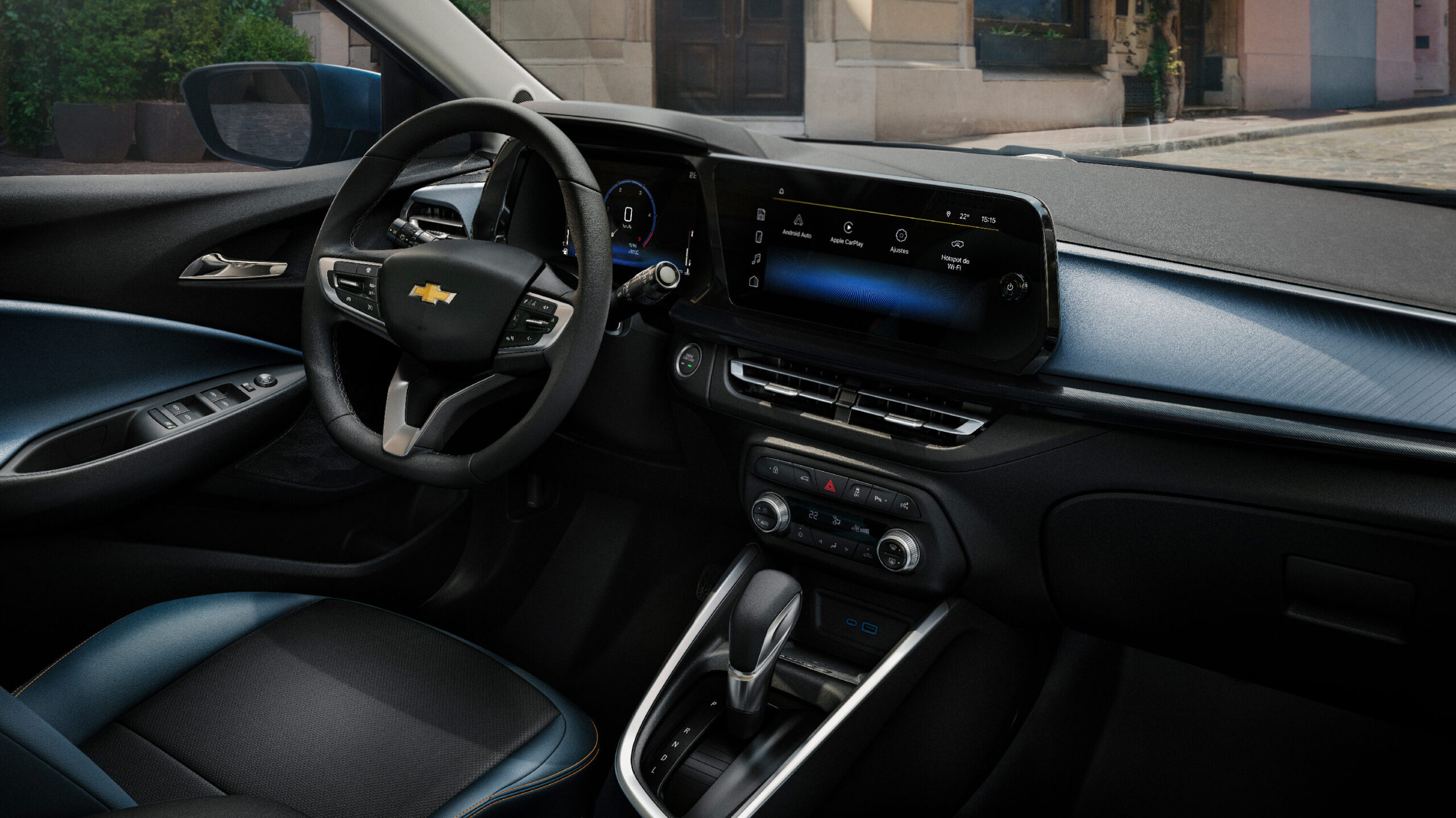 Interior view of a Chevrolet car, featuring a steering wheel, touchscreen display, and gear shift console.
