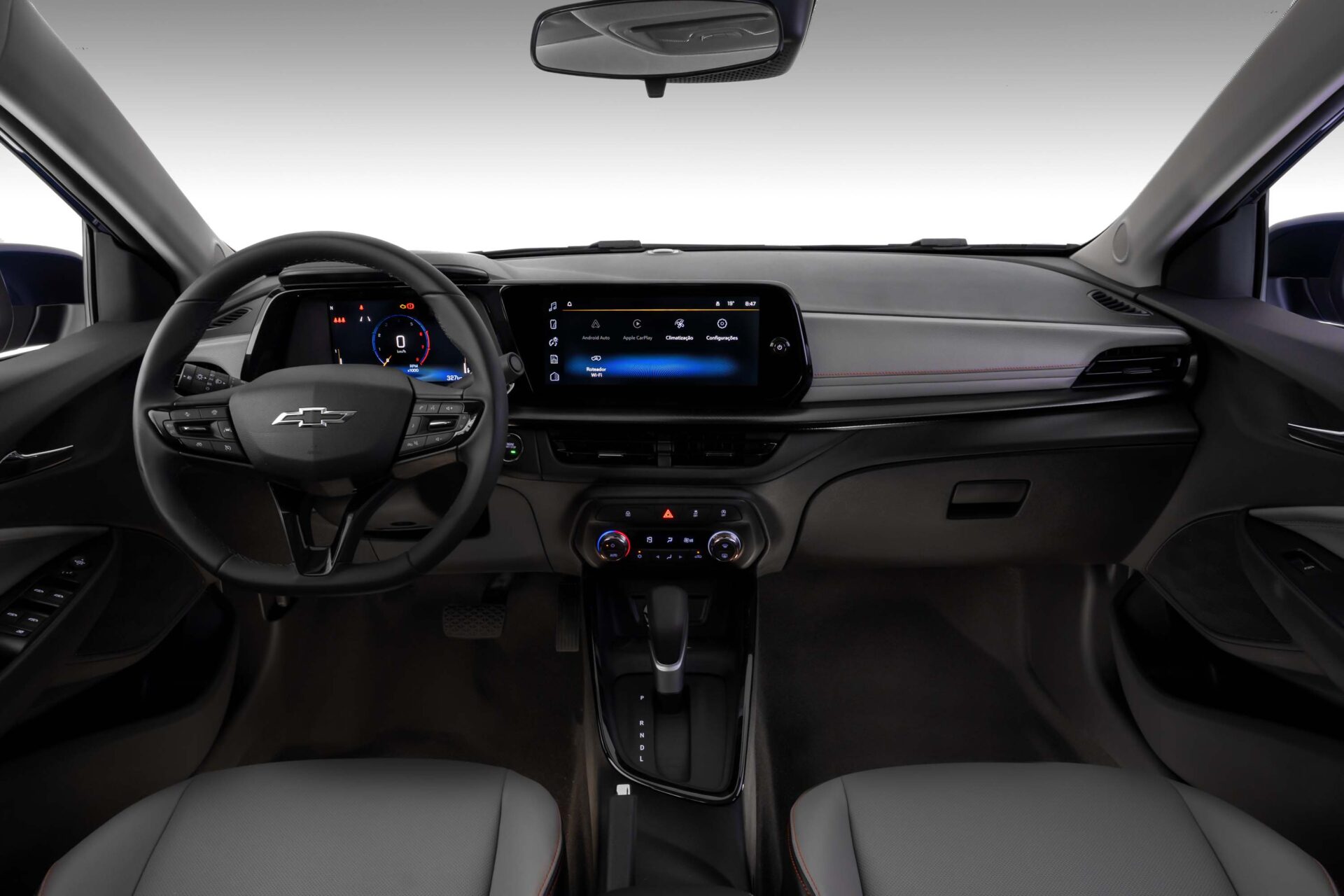 Interior view of a Chevrolet car showcasing the steering wheel, digital dashboard display, and center console with various controls and touchscreen.