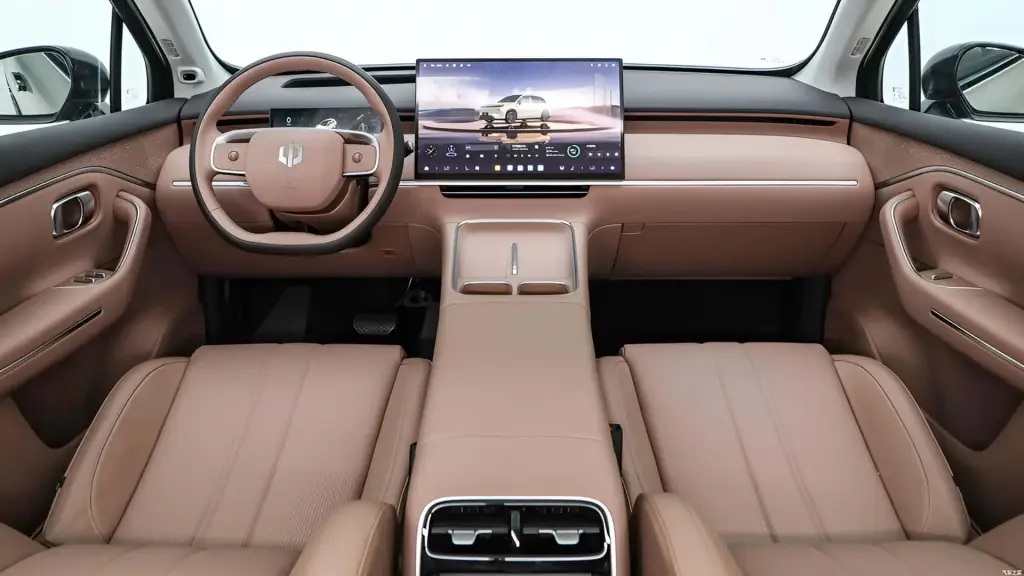 Interior view of a modern car featuring a brown leather dashboard, a digital display screen, a circular steering wheel, and padded seats.