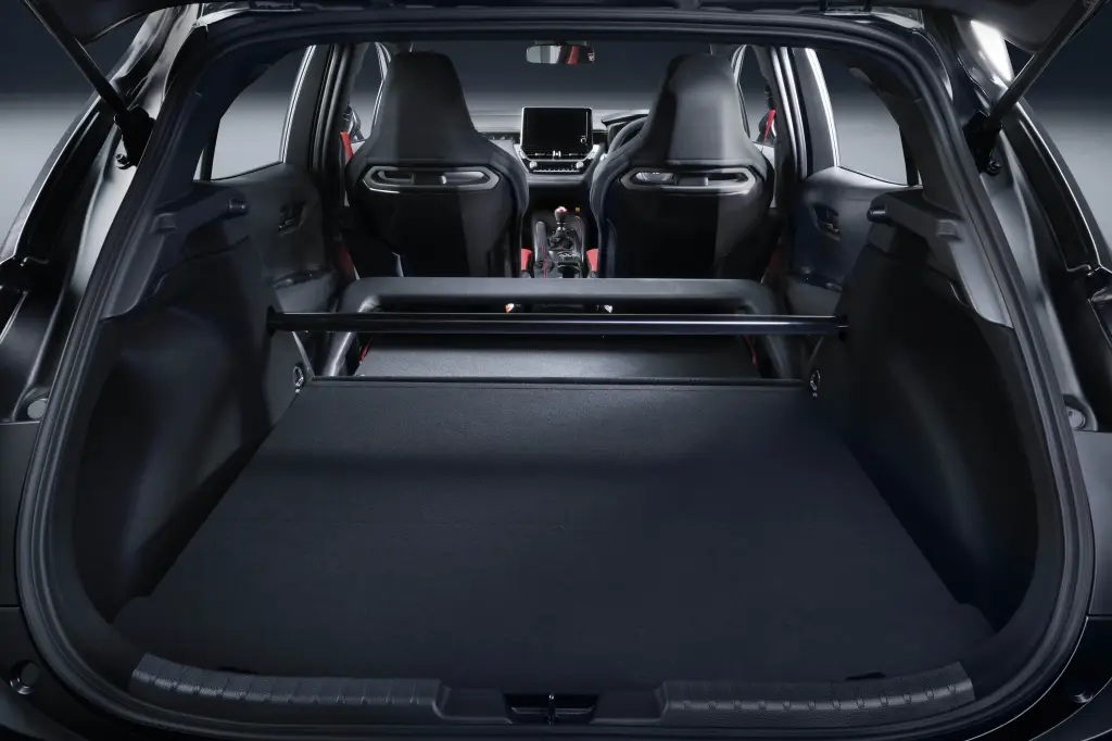 Interior view of a car trunk, showcasing the spacious cargo area with a flat floor and a rear shelf, looking towards the front seats.