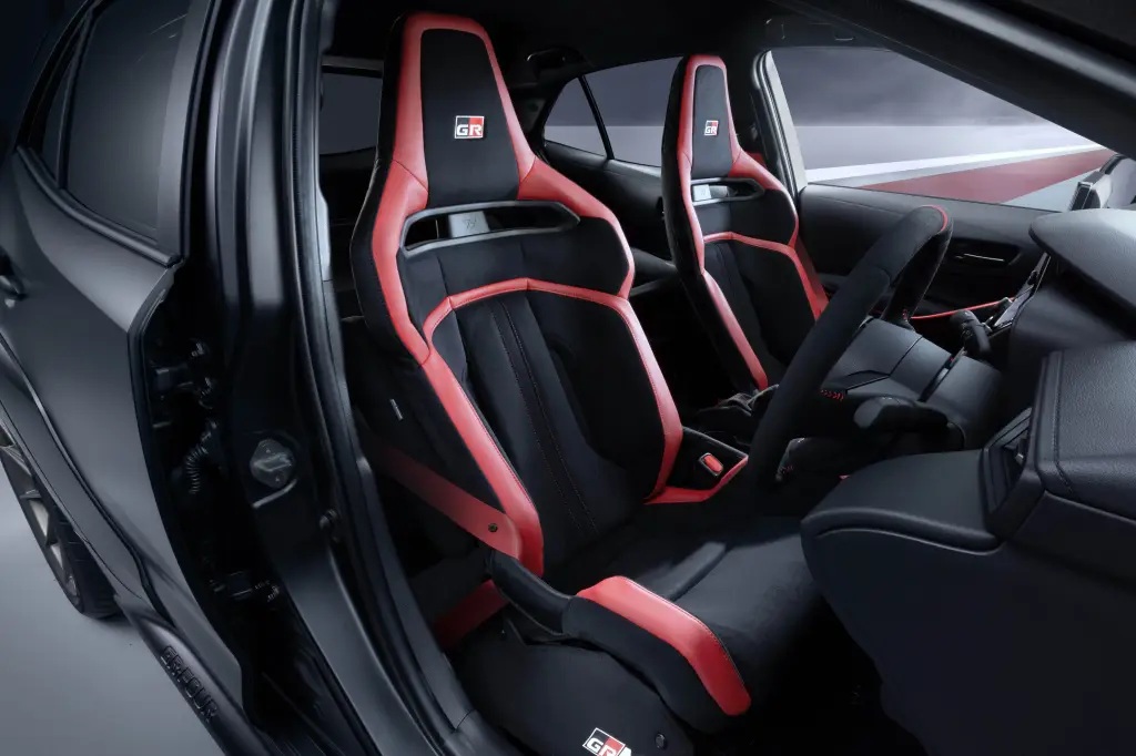 Interior view of a car showcasing sporty black and red racing seats with a modern design.