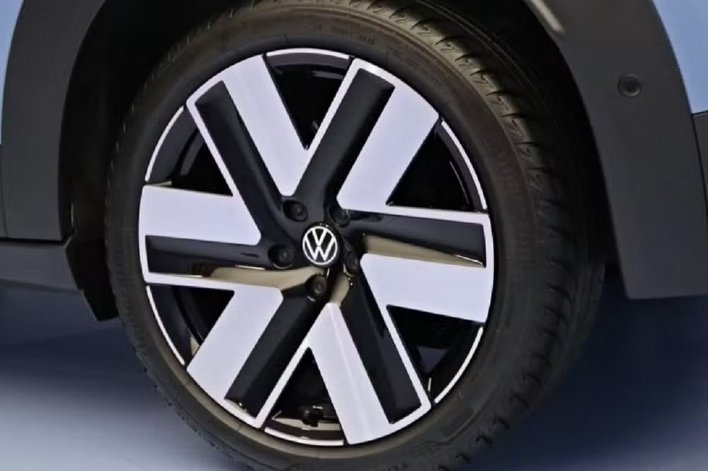 Close-up of a Volkswagen car wheel with a modern design featuring a black and white split rim and a sturdy tire.