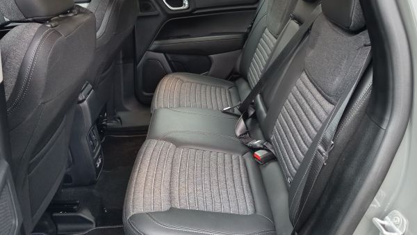 Bancos traseiros de um carro, com estofamento em tecido cinza e detalhes em couro preto.