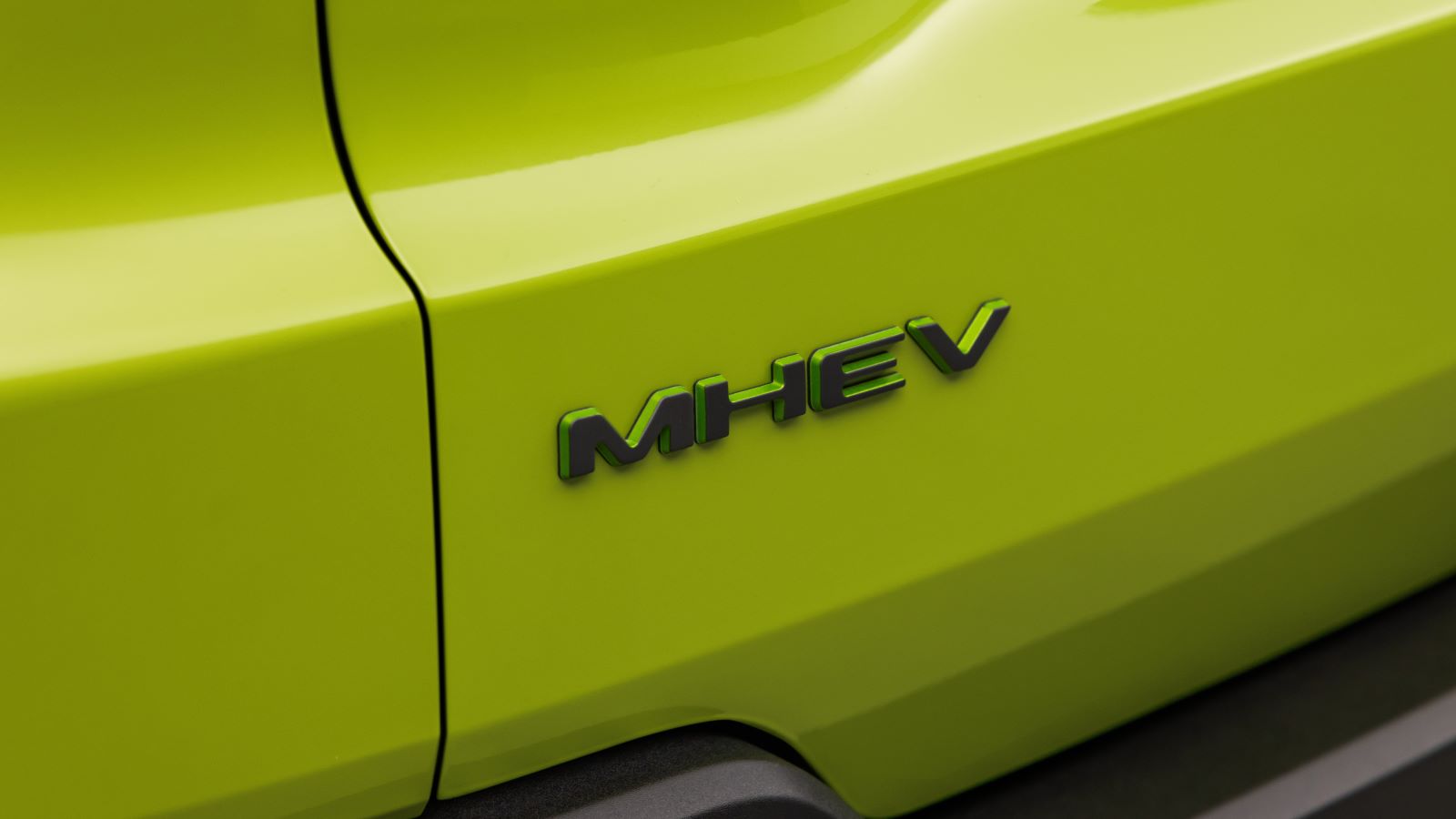 Detalhe da parte traseira de um veículo com a inscrição MHEV em destaque sobre uma superfície verde-limão.