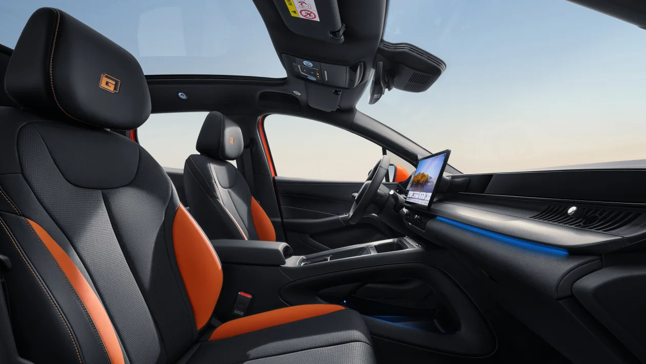 Interior moderno de carro com assentos em couro preto e laranja, painel digital e iluminação azul.